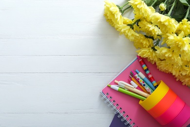 Photo of Beautiful flowers and stationery on white wooden background, flat lay with space for text. Teacher's Day