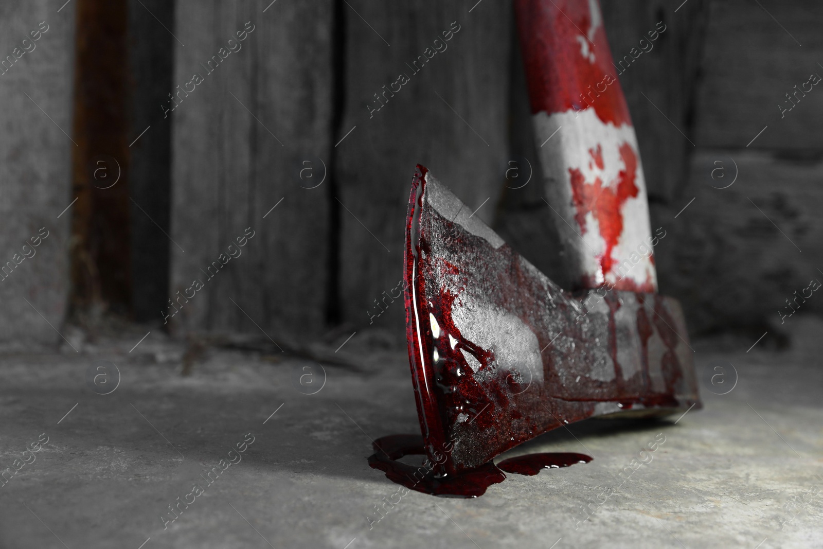 Photo of Axe with blood on floor indoors, closeup. Space for text