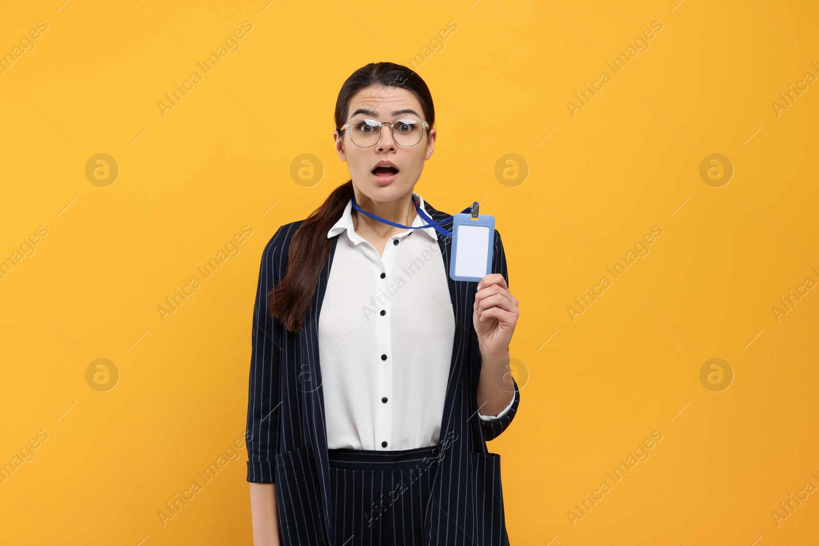 Photo of Shocked woman with vip pass badge on orange background