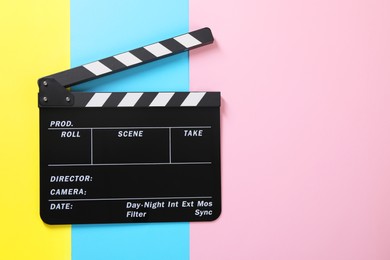 Photo of Clapperboard on color background, top view. Space for text