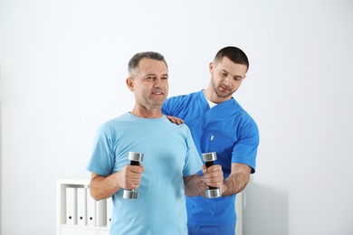 Photo of Doctor working with patient in hospital. Rehabilitation exercises