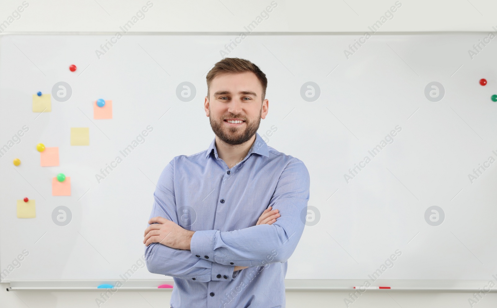 Photo of Portrait of young teacher near whiteboard in classroom