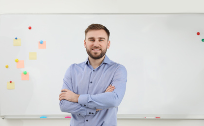 Photo of Portrait of young teacher near whiteboard in classroom