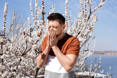 Man suffering from seasonal allergy outdoors on sunny day