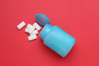 Photo of Jar with chewing gums on red background, flat lay