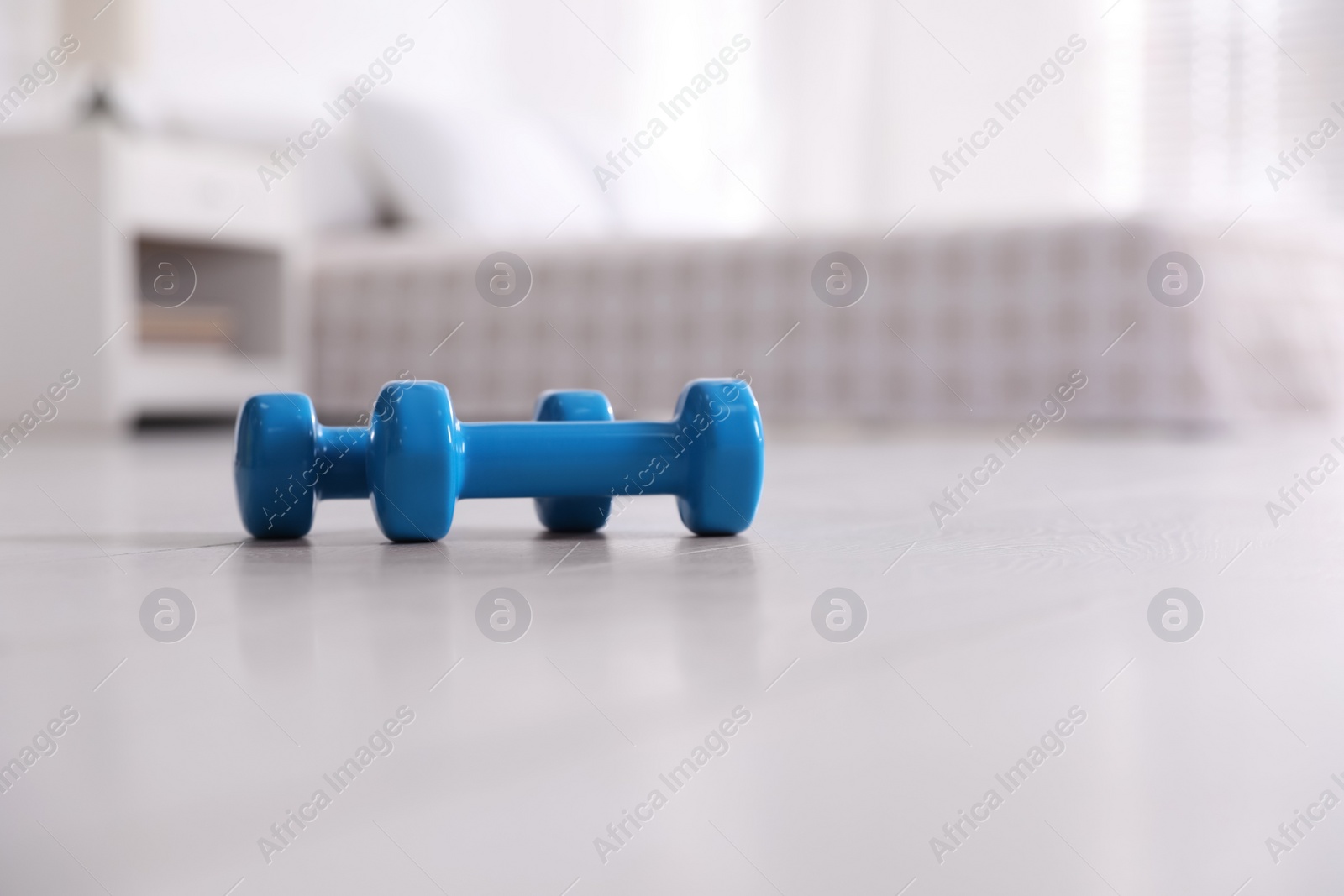 Photo of Blue dumbbells on floor in room, space for text. Home fitness