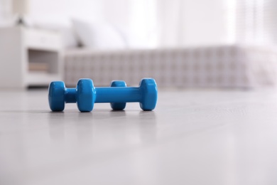 Photo of Blue dumbbells on floor in room, space for text. Home fitness