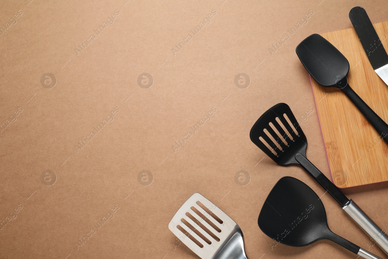 Photo of Different spatulas on brown background, flat lay. Space for text