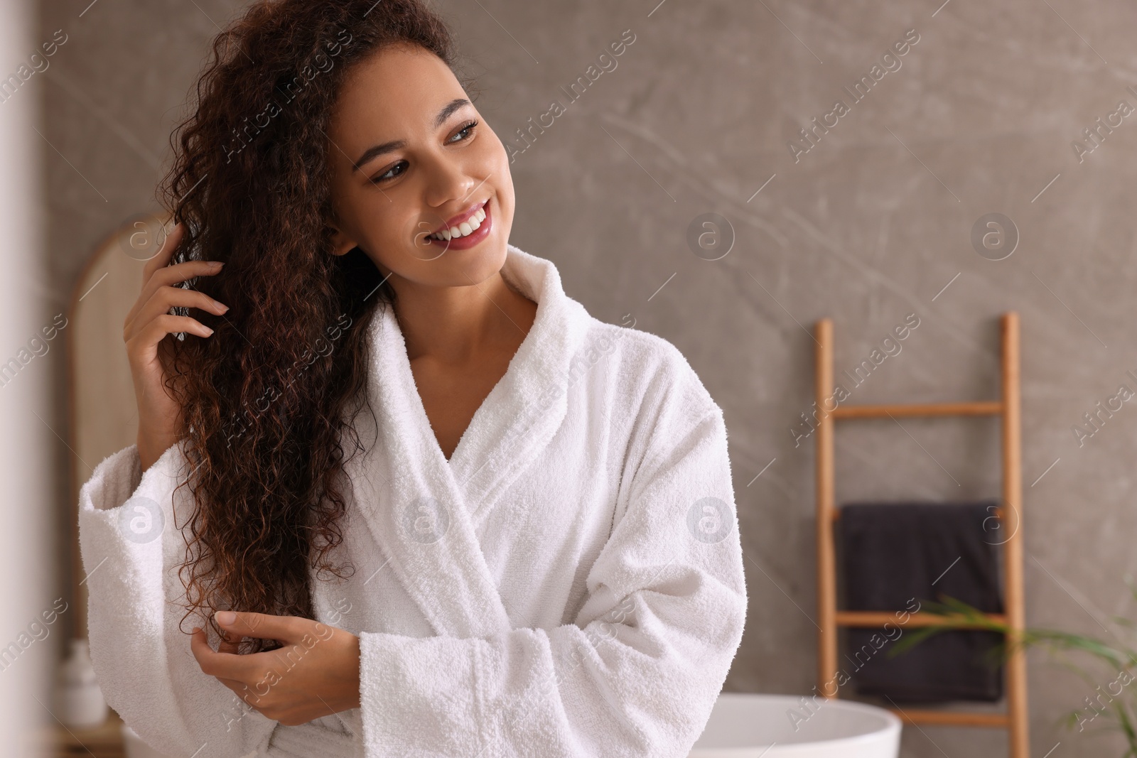 Photo of Beautiful African American woman in bathroom, space for text