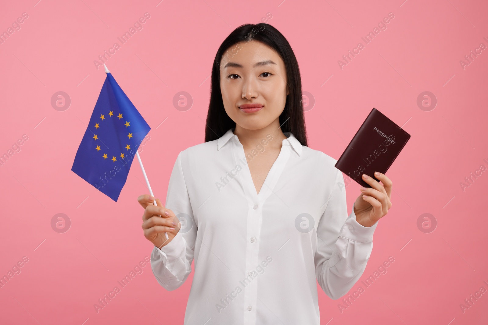 Photo of Immigration to European Union. Woman with passport and flag on pink background