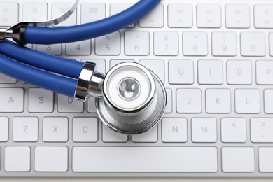 Photo of Keyboard and stethoscope on beige background, top view