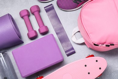 Different sports equipment on light grey table, flat lay