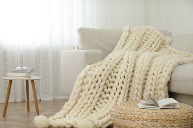 Photo of Knitted merino wool plaid on sofa in room