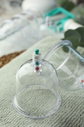 Photo of Cupping therapy. Plastic cups on soft towel, closeup