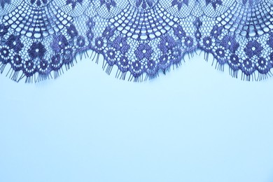 Photo of Beautiful lace on light blue background, top view. Space for text