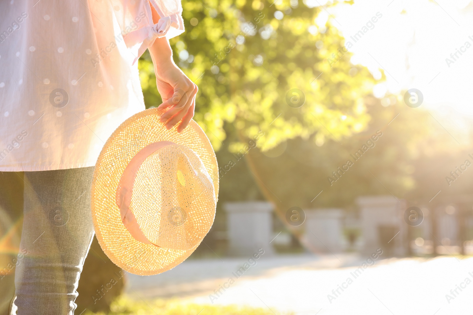 Photo of Young woman with straw hat outdoors on sunny day, closeup. Space for text