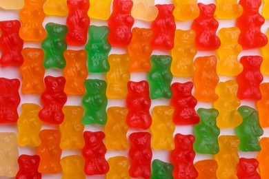 Many delicious little jelly bears on white background, flat lay