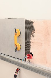 Yellow suction plate attached to tile on wall