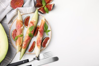Photo of Tasty melon, jamon and figs served on white table, flat lay. Space for text