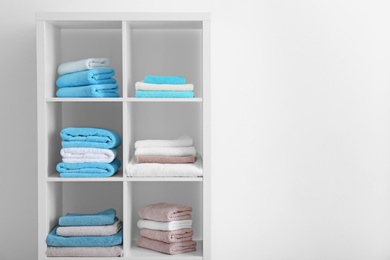 Photo of Clean towels on shelves in bathroom