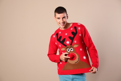 Photo of Portrait of happy man in Christmas sweater on beige background