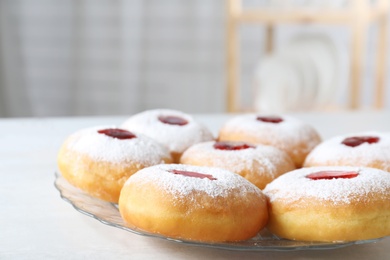Photo of Hanukkah doughnuts with jelly and sugar powder served on wooden table, closeup
