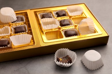 Photo of Partially empty box of chocolate candies on grey table