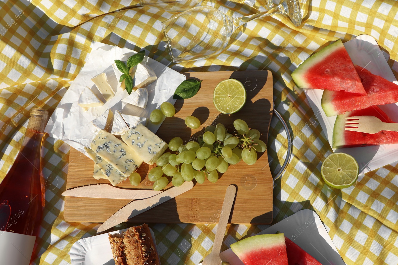 Photo of Delicious food and wine on picnic blanket, flat lay