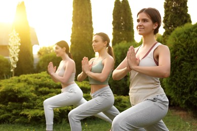Photo of Group of young women practicing yoga outdoors