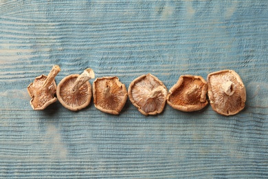 Photo of Flat lay composition of dried mushrooms on color wooden background