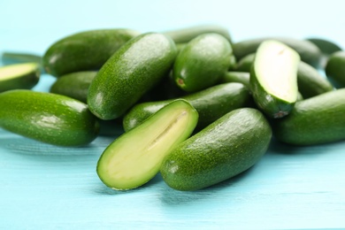 Photo of Fresh seedless avocados on turquoise table, closeup