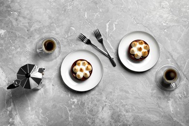 Photo of Delicious salted caramel chocolate tarts with meringue and coffee on light grey marble table, flat lay