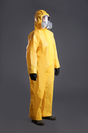 Photo of Woman wearing chemical protective suit on grey background. Virus research
