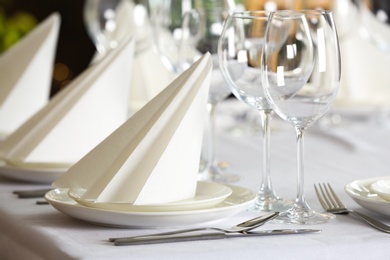 Photo of Table setting with empty glasses, plates and cutlery indoors