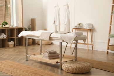 Photo of Stylish massage room interior with spa table in salon