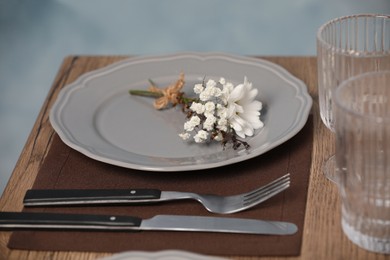 Photo of Elegant festive setting with floral decor on wooden table