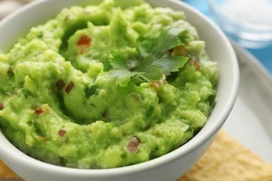 Delicious guacamole with parsley on table, closeup