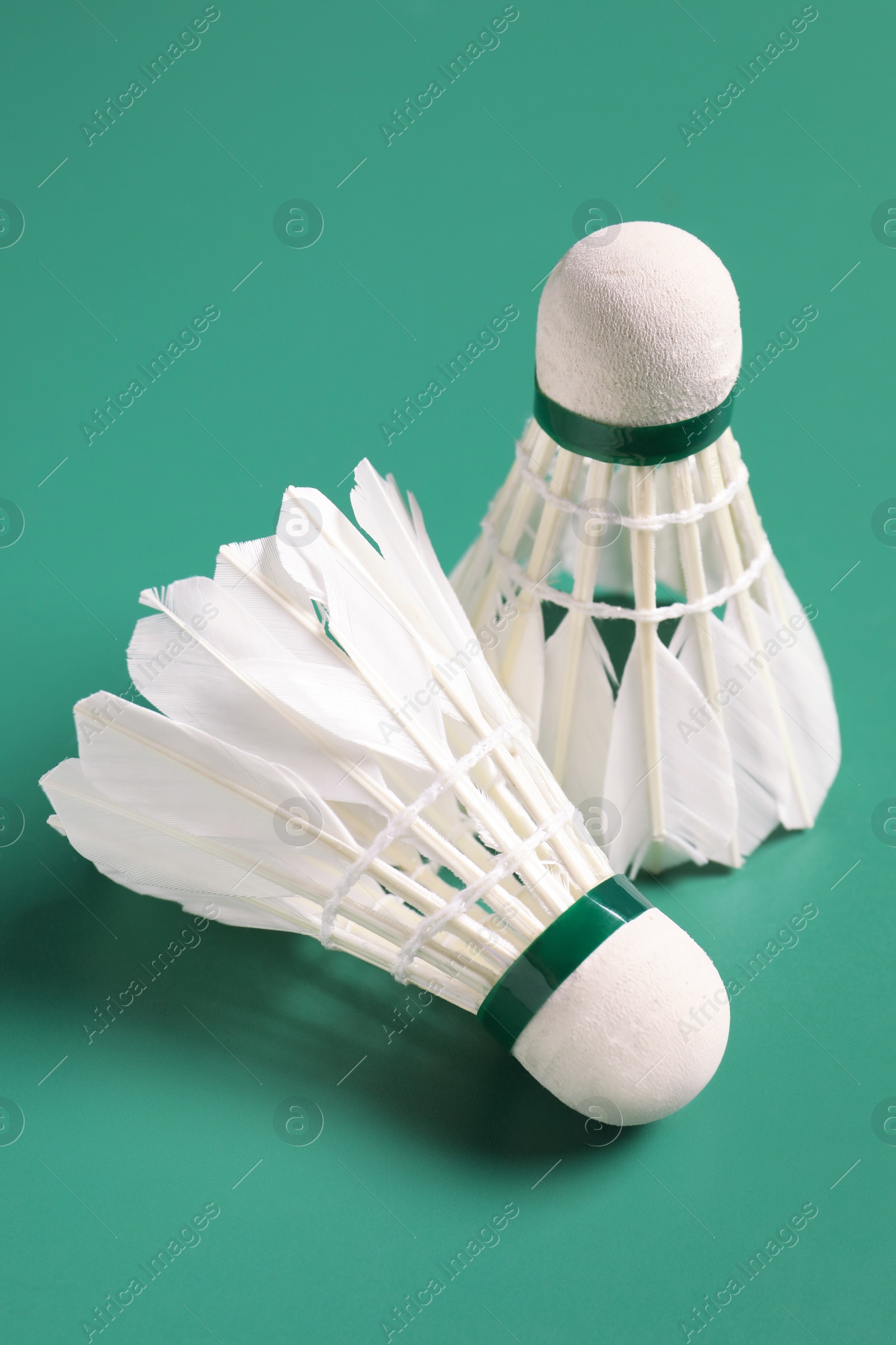 Photo of Feather badminton shuttlecocks on green background, closeup