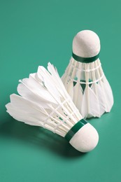 Photo of Feather badminton shuttlecocks on green background, closeup