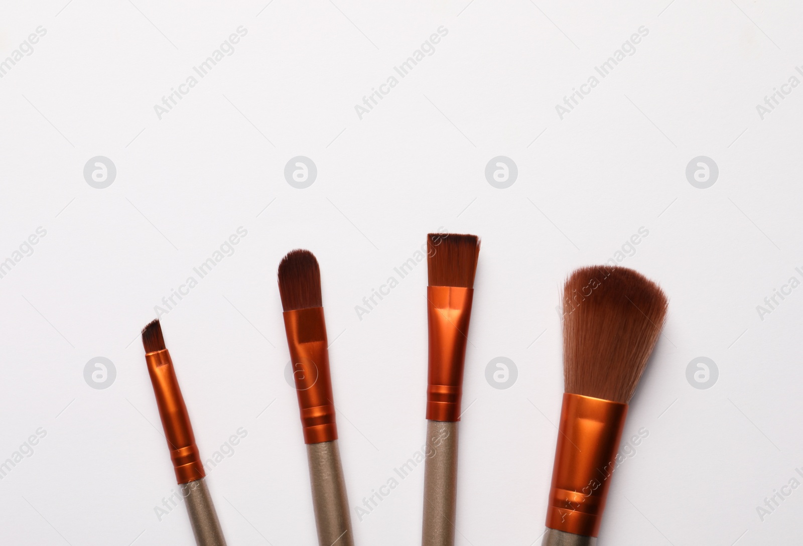 Photo of Set of makeup brushes on white background, flat lay. Space for text