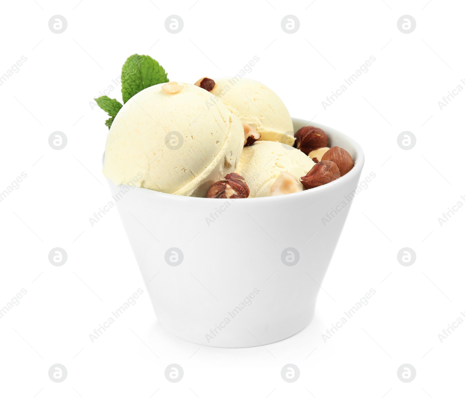 Photo of Delicious vanilla ice cream with hazelnuts and mint in dessert bowl on white background