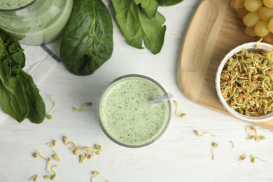 Flat lay composition with green buckwheat smoothie on white wooden table