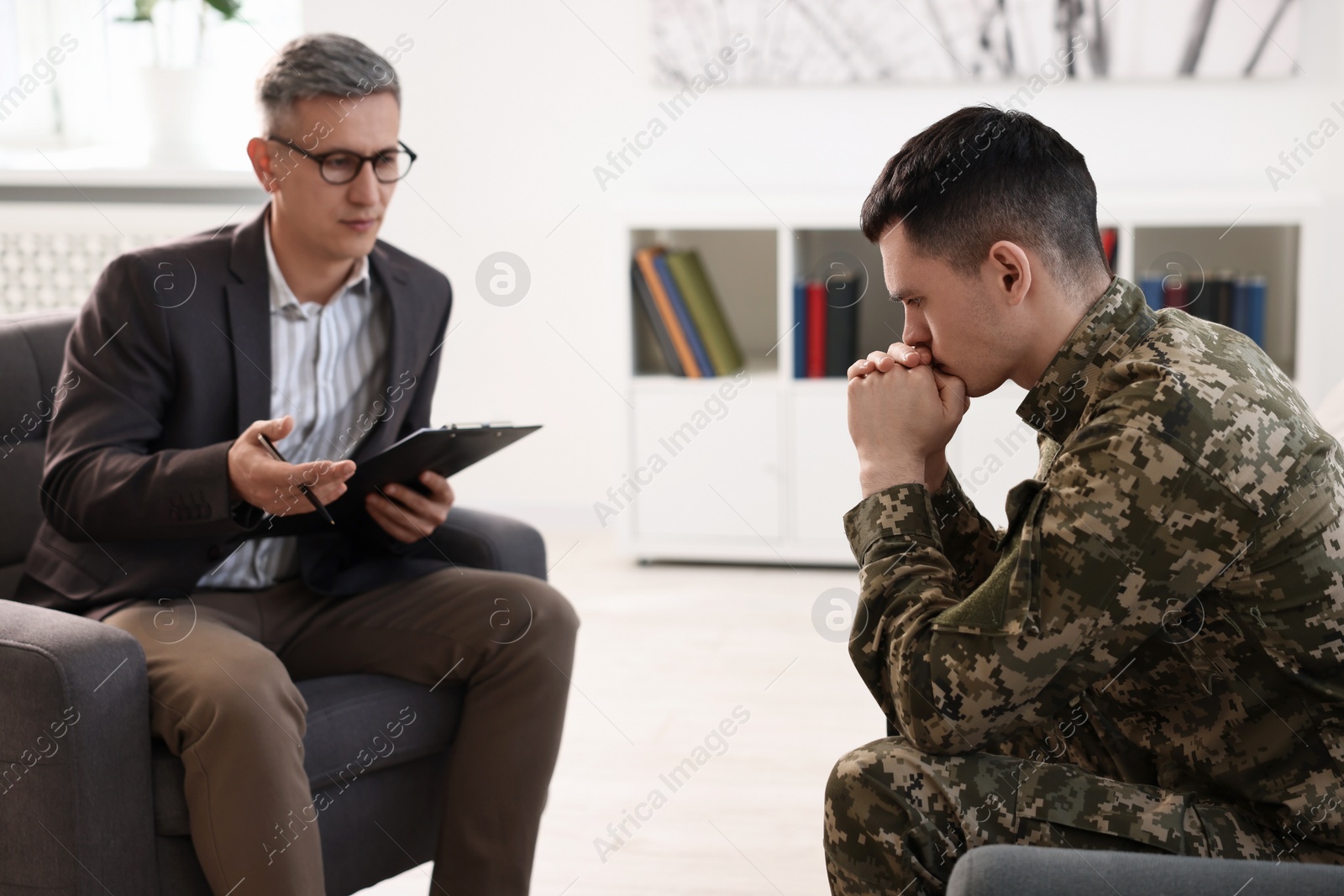 Photo of Professional psychotherapist working with military man in office