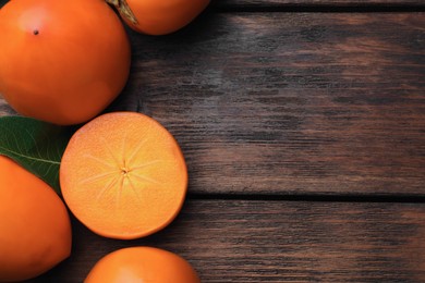 Photo of Delicious ripe persimmons on wooden table, flat lay. Space for text
