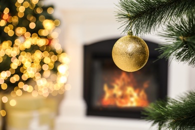 Photo of Beautiful holiday bauble hanging on Christmas tree against blurred lights