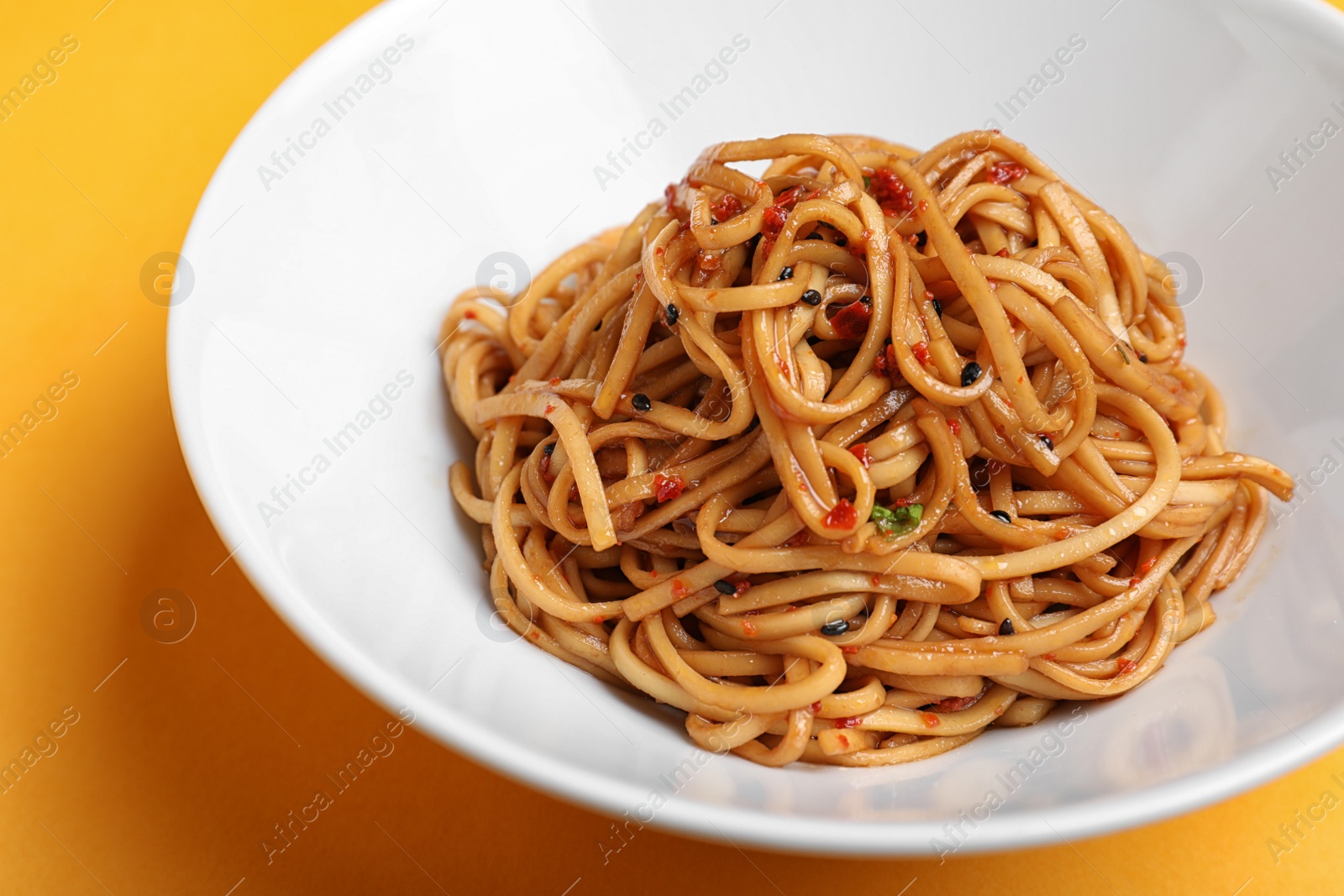 Photo of Tasty cooked noodles on orange background, closeup
