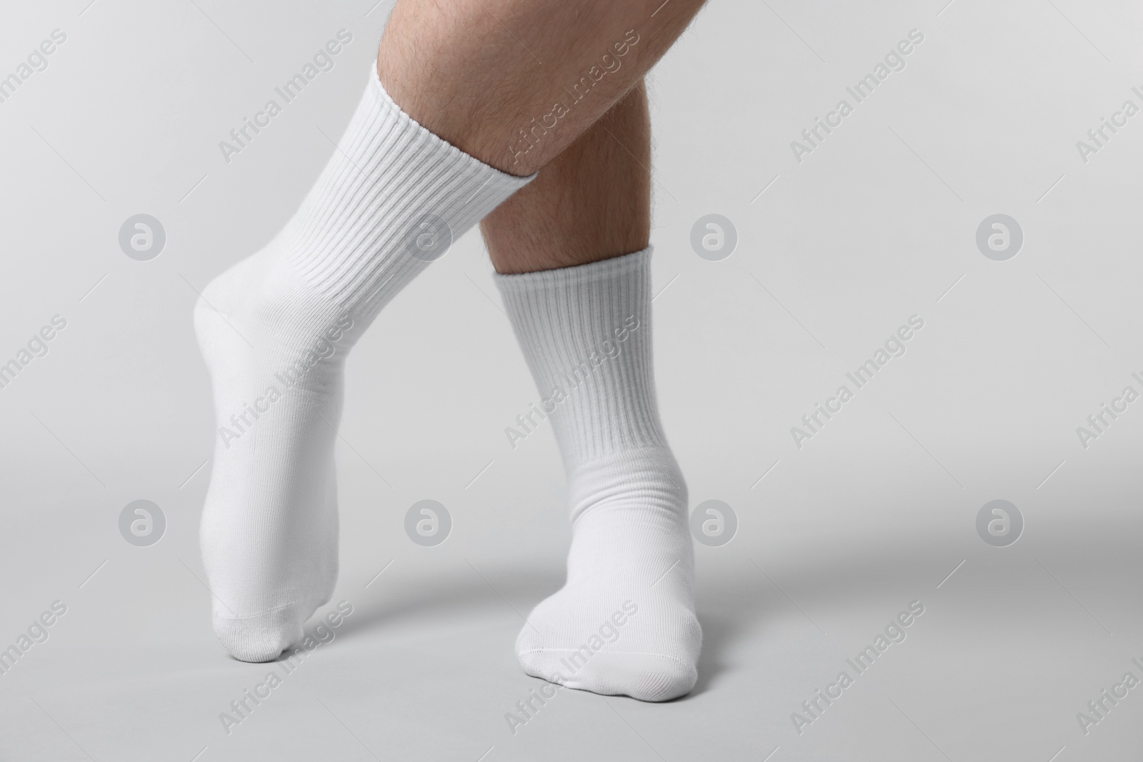 Photo of Man in stylish white socks on light grey background, closeup. Space for text