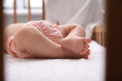Photo of Cute little baby sleeping in crib at home, closeup