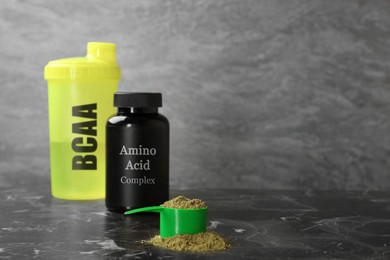 Image of Shaker with abbreviation BCAA, Amino Acid complex in plastic jar and powder on table. Space for text 