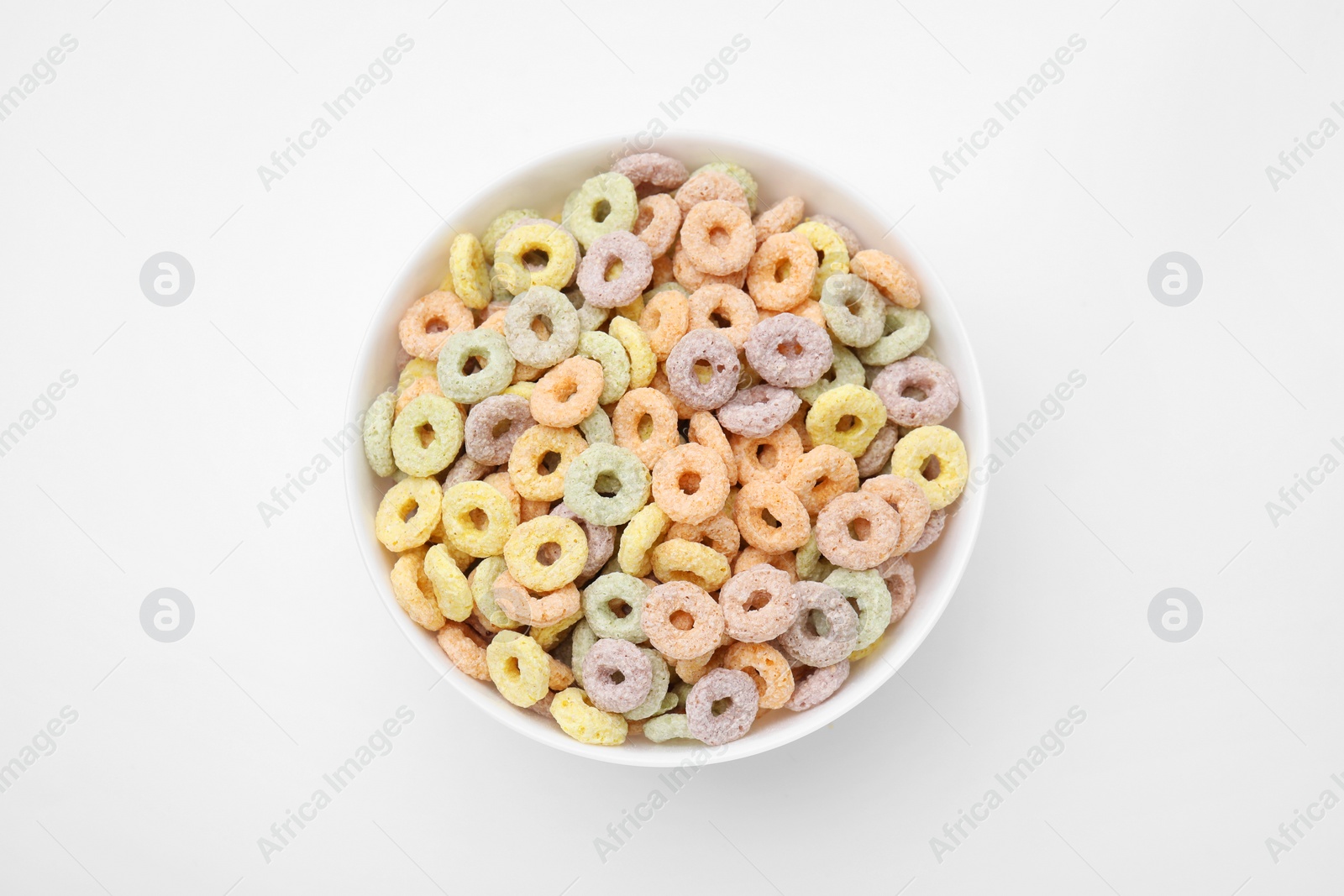 Photo of Tasty cereal rings in bowl on white table, top view